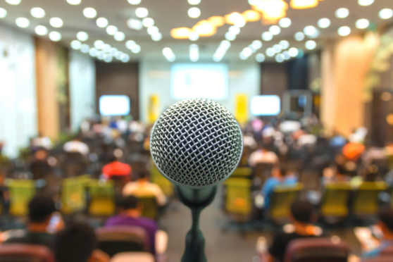 Microphone over the Abstract blurred photo of conference hall