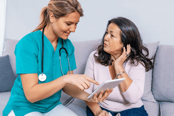 Nurse talking to patient and pointing at tablet