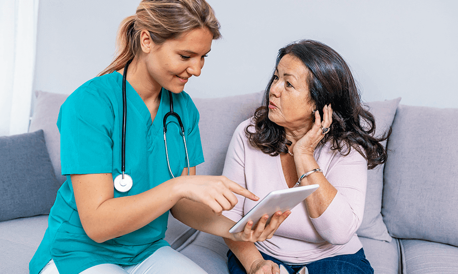 Nurse talking to patient and pointing at tablet